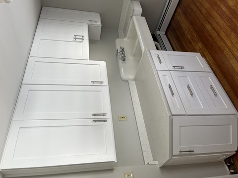 an overhead view of a kitchen with white cabinets and drawers