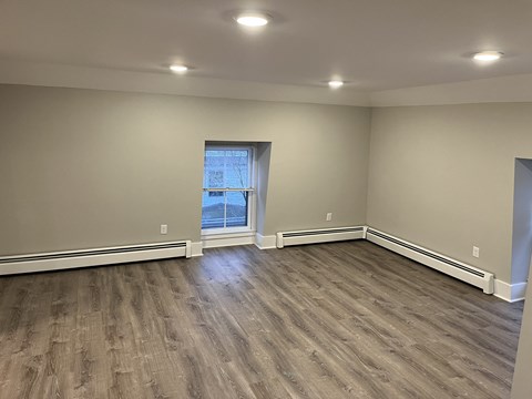 a living room with wood floors and a window