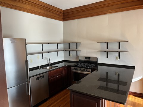 a kitchen with stainless steel appliances and black counter tops