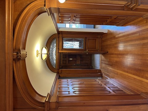 a view of a wood staircase from an oval window