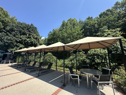 A patio with a table and chairs under a canopy.