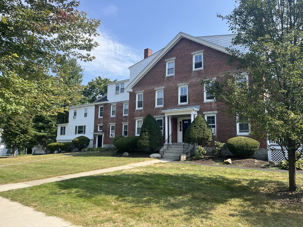 a house with a lawn and trees in front of it
