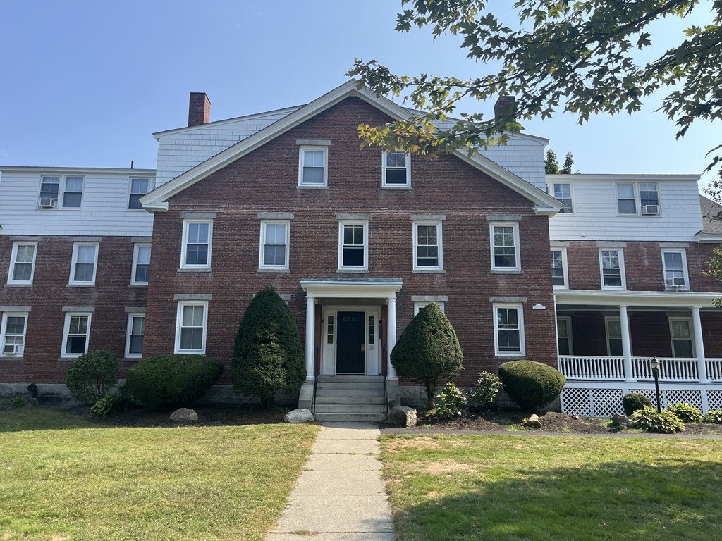 a red brick house with a sidewalk in front of it