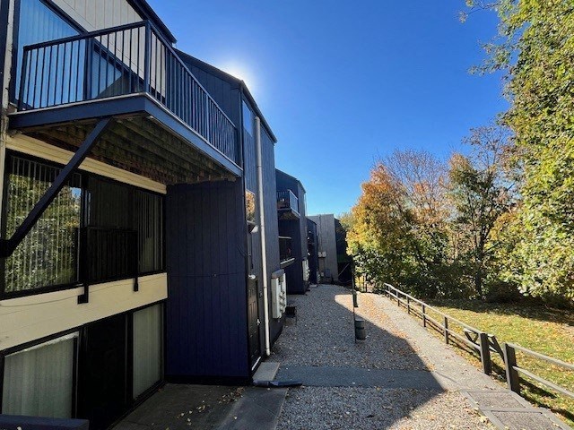 A sunny day at a modern building with a gravel pathway leading to a gate.