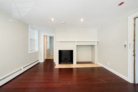 a living room with a fireplace and a wooden floor