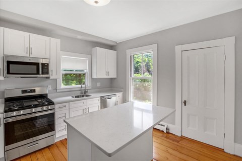a kitchen with white cabinets and stainless steel appliances