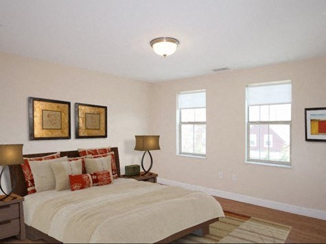 a bedroom with a bed and two windows