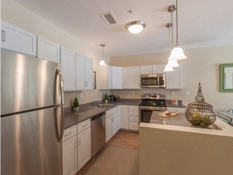 a kitchen with stainless steel appliances and white cabinets