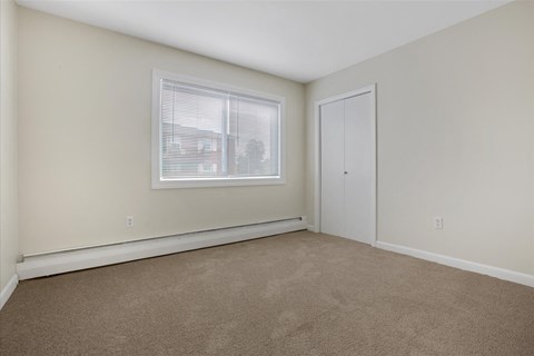 a bedroom with carpet and a window and a door