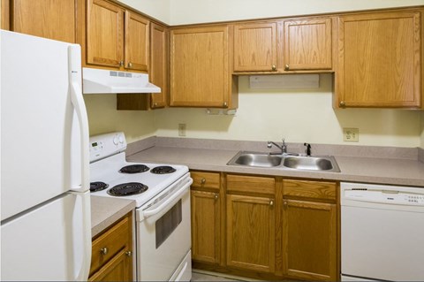 a kitchen with white appliances and wooden cabinets