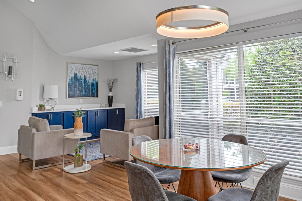 Living room with a table and chairs and a large window  at Harrison Grande, Cary, 27513
