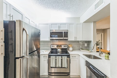 a kitchen with stainless steel appliances and white cabinets