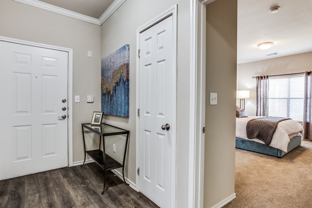 a bedroom with two closets and a door to a room with a bed at Village of Hawks Creek Apartments, Westworth Village