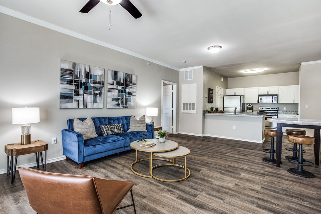 a living room with a blue couch and a table at Village of Hawks Creek Apartments, Westworth Village, 76114