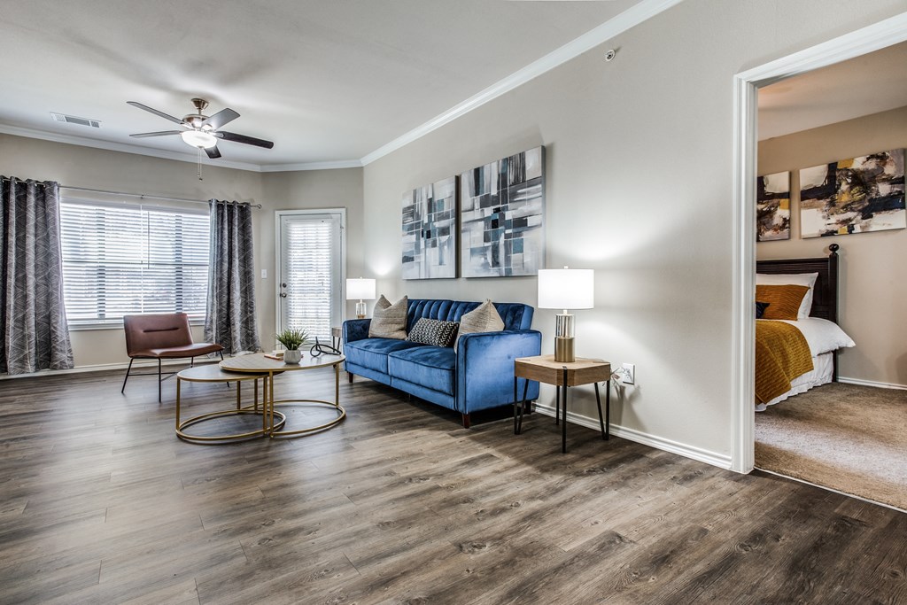 a living room with a couch and a ceiling fan at Village of Hawks Creek Apartments, Westworth Village, TX