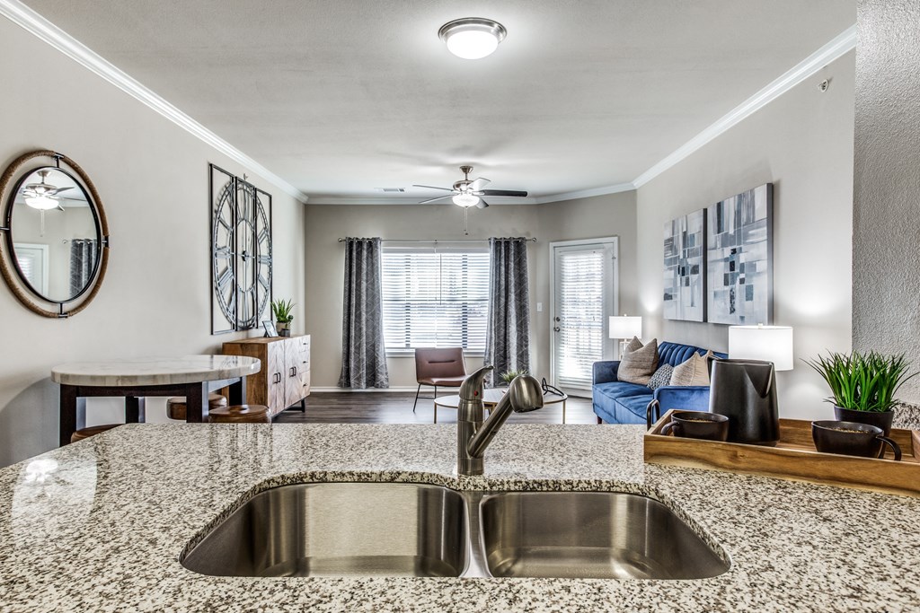a kitchen with a sink and a view of a living room at Village of Hawks Creek Apartments, Texas, 76114