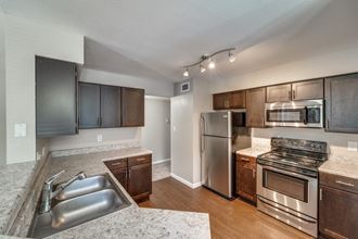 an open kitchen with stainless steel appliances and granite counter tops