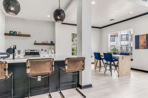 a kitchen with a bar and a table with chairs
