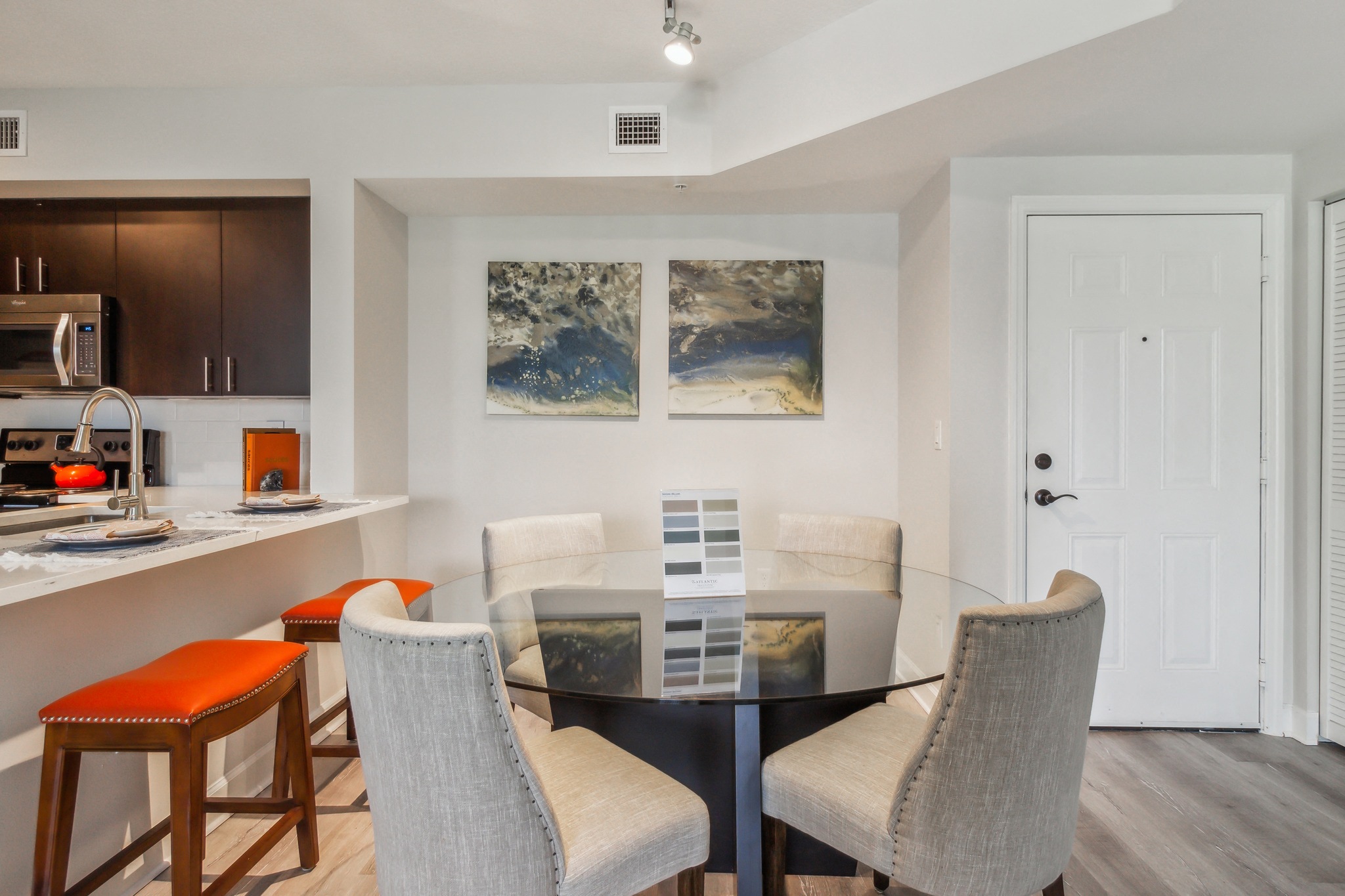 a kitchen and dining room with a glass table and chairs