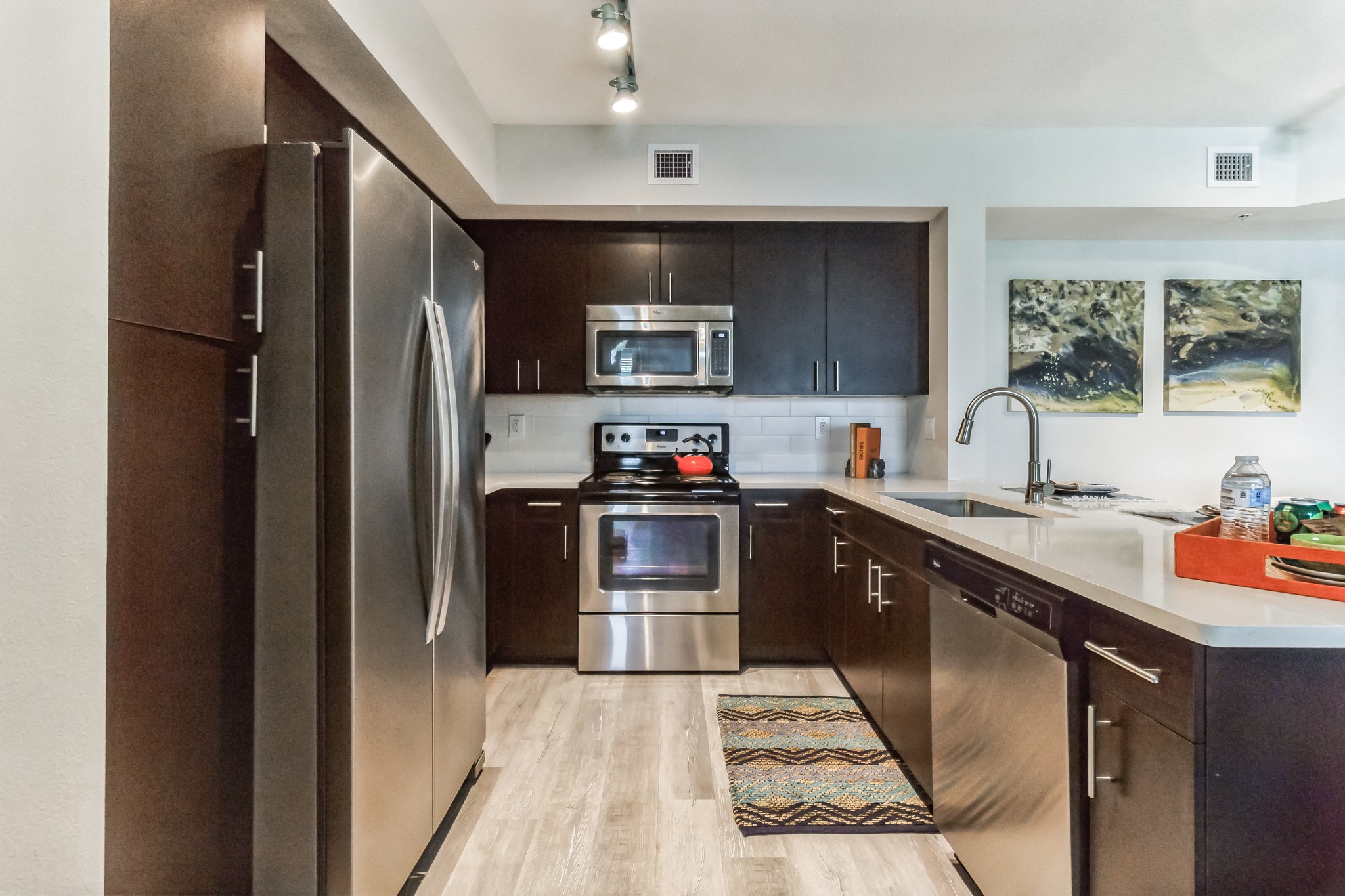 a modern kitchen with stainless steel appliances and wooden cabinets