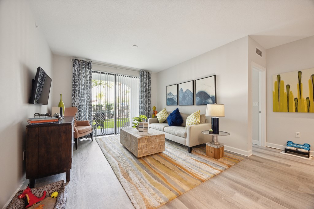 Living room of an apartment with a couch and a tv at The Atlantic at Tradition, Port St Lucie, Florida