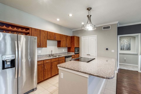 a kitchen with a counter top and a stainless steel refrigerator
