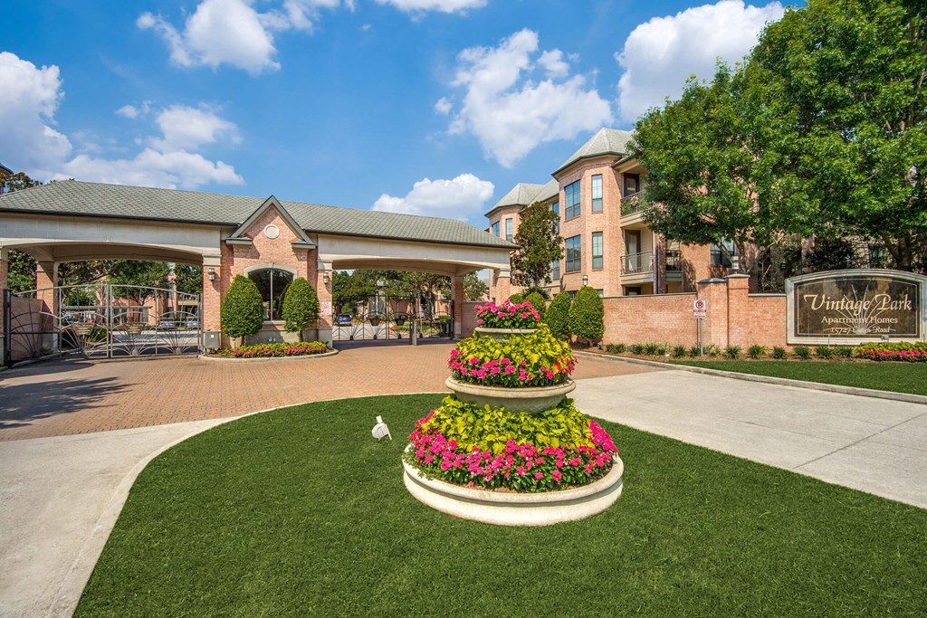 Courtyard with a large flower bed and a building in the background at Vintage Park Apartments, Houston