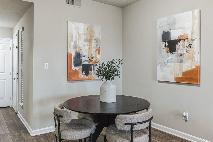 a dining room with paintings on the wall and a table with chairs  at Harrison Grande, Cary, NC, 27513