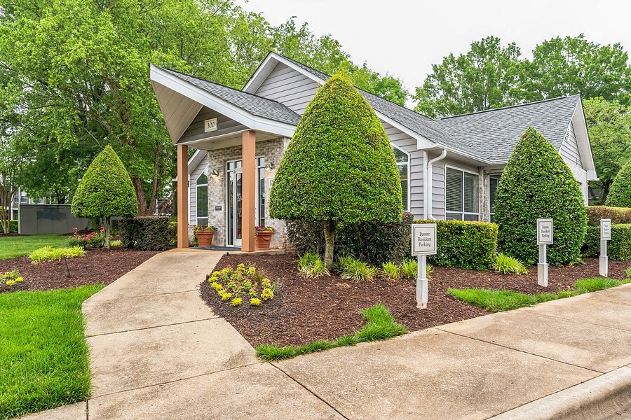 a small gray house with a driveway and a sign in front of it  at Harrison Grande, Cary, NC, 27513