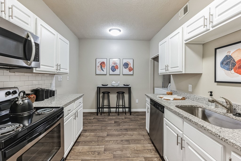 a spacious kitchen with white cabinets and granite counter tops  at Harrison Grande, Cary, 27513