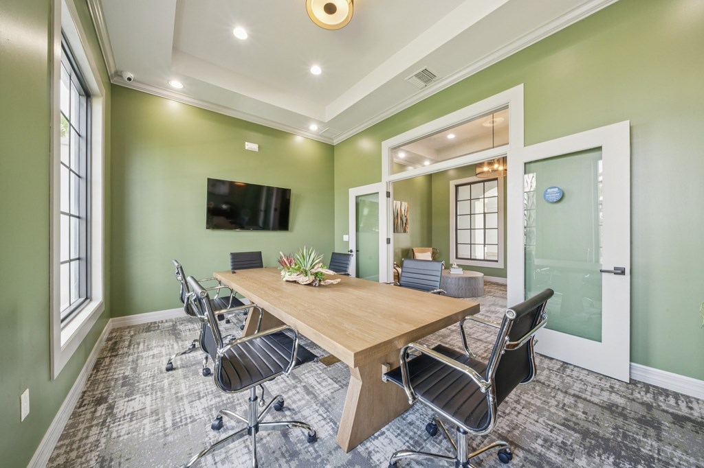 A conference room with a long table and chairs.