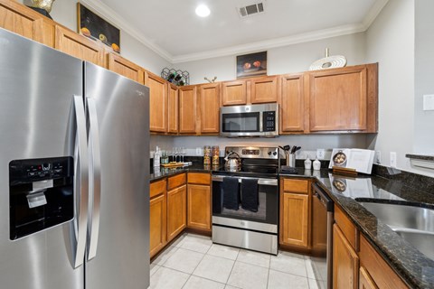 A modern kitchen with wooden cabinets and stainless steel appliances.