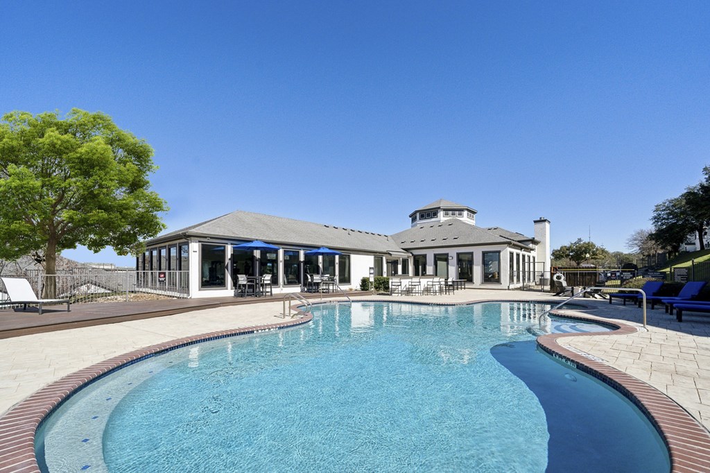 A large swimming pool in front of a house.