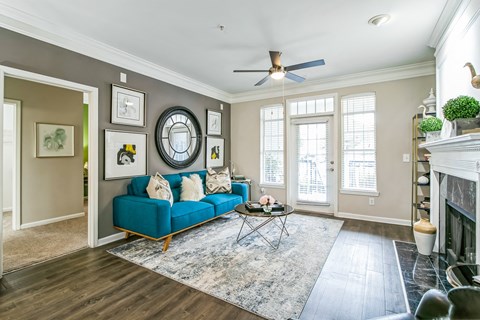A living room with a blue couch and a rug.