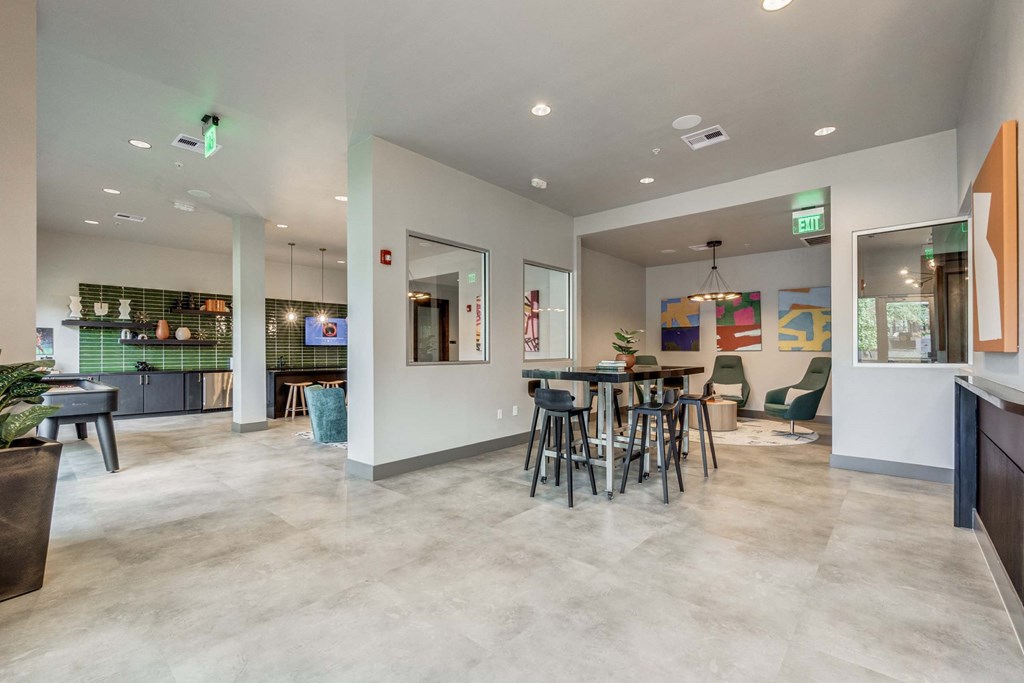 Clubhouse with a dining area and a bar with chairs and tables at The Atlantic Highland Park, Texas