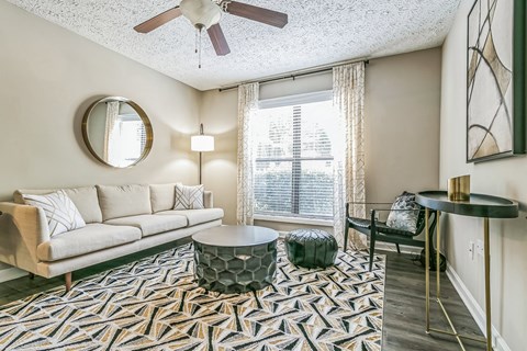 a living room with a couch and a chair and a window