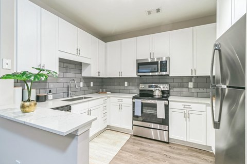 a kitchen with white cabinets and stainless steel appliances