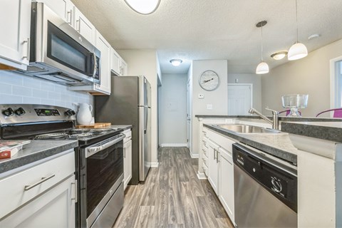 an open kitchen with stainless steel appliances and white cabinets