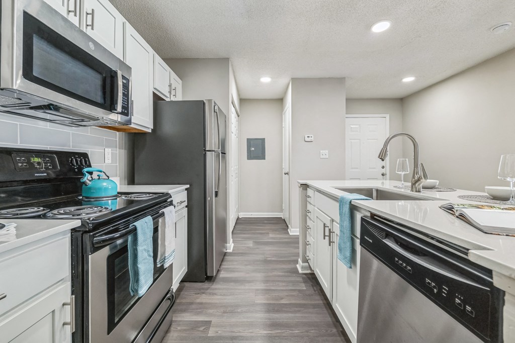 an empty kitchen with white cabinets and stainless steel appliances at Magnolia Terrace Apartments, North Carolina 28213