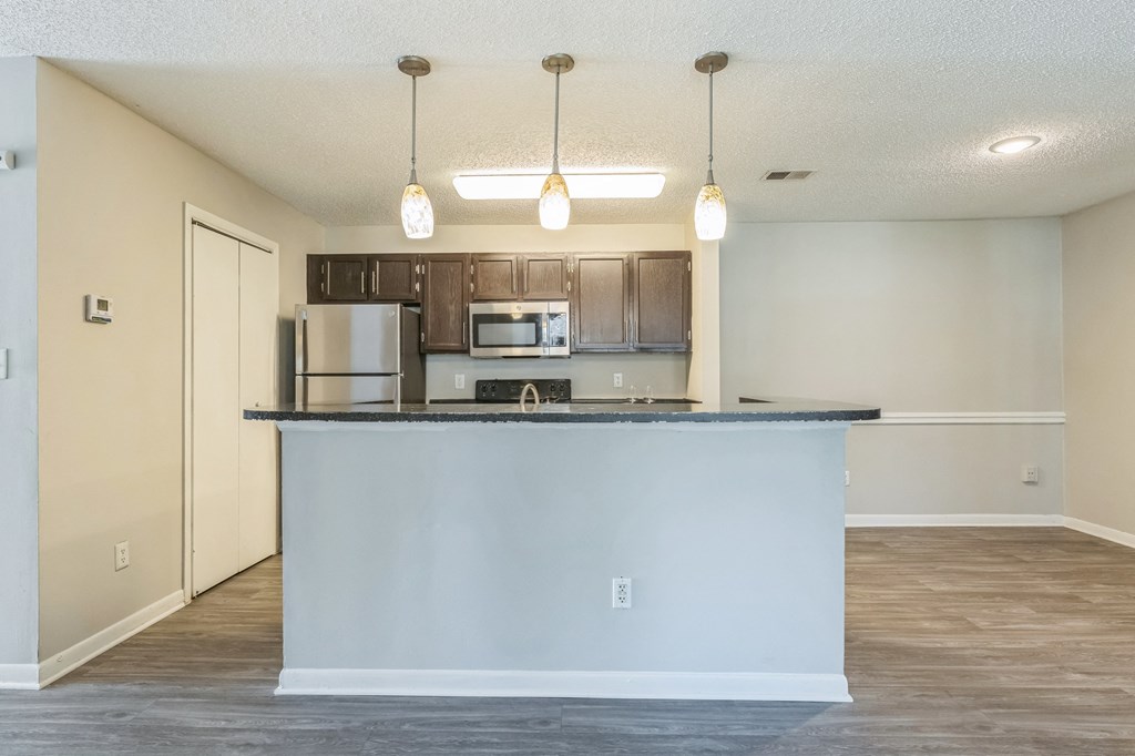 A kitchen with a white counter and brown cabinets at Magnolia Terrace Apartments, Charlotte, NC
