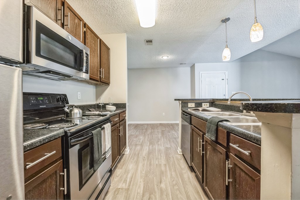 an open kitchen with stainless steel appliances and wooden cabinets at Magnolia Terrace Apartments, Charlotte, NC, 28213