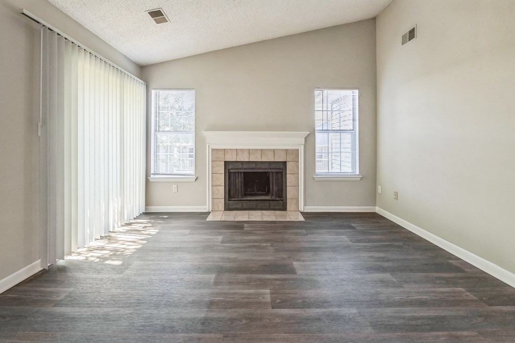 an empty living room with a fireplace and windows at Magnolia Terrace Apartments, Charlotte, 28213