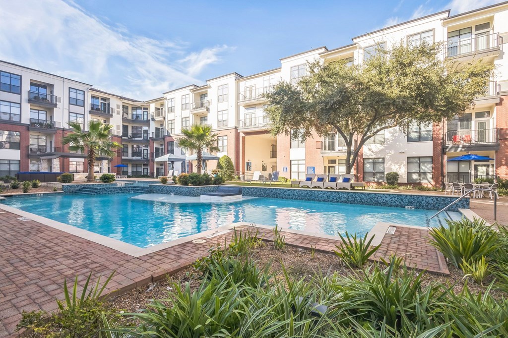 Swimming pool A swimming pool surrounded by a brick border and palm trees in front of apartment buildings at The Atlantic Memorial, Houston