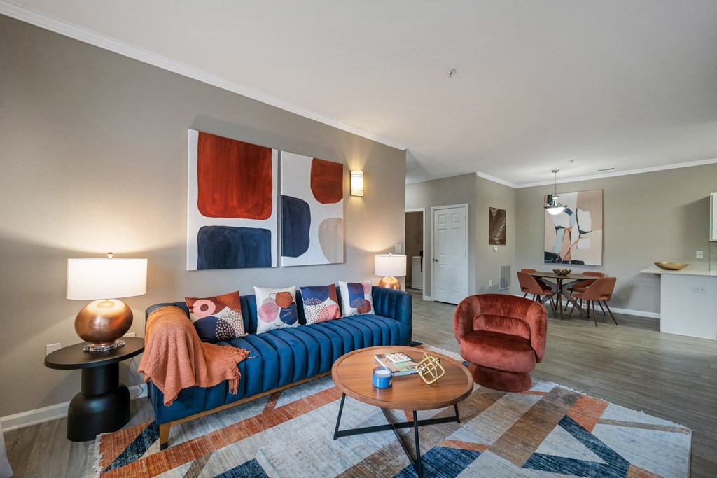 a living room with a blue couch and a red chair