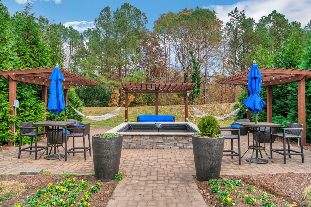 a patio with a pool and tables and umbrellas