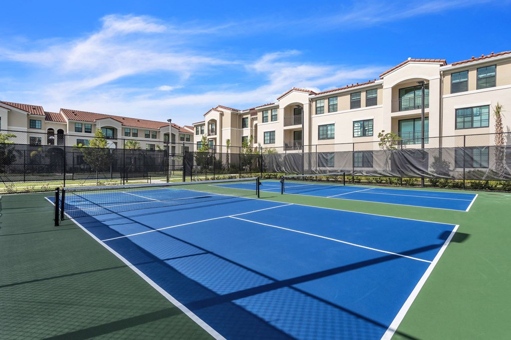 two tennis courts at the flats at big tex apartments in san antonio, tx