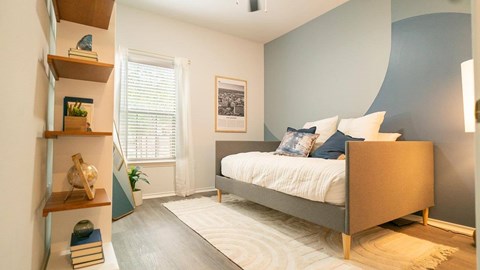 Bedroom with modern decor and wooden shelving at The Palmera Apartments, Schertz, Texas