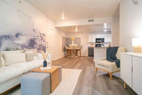 A living room with a white couch and a grey ottoman.