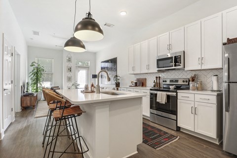 Open kitchen with white cabinets and a large island at Arcadia Decatur, Decatur, GA.