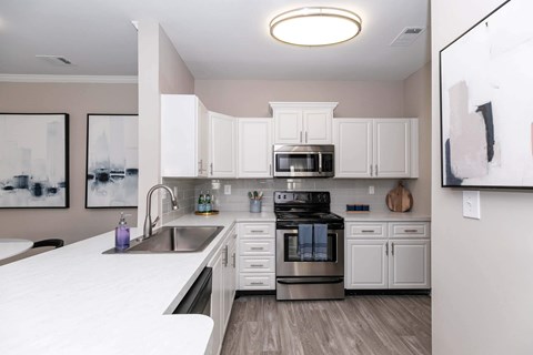 a white kitchen with stainless steel appliances and white cabinets